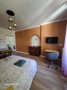 a bedroom with a bed and a desk and a television at Ty Méluzhine in Huelgoat