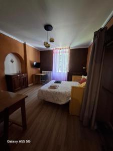 a bedroom with a bed and a table and a window at Ty Méluzhine in Huelgoat