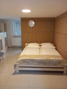 a bedroom with a large bed with a wooden headboard at apartmandomazlice in Domažlice