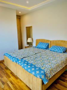 a large bed with blue pillows in a bedroom at Snowra heights in Abbottabad