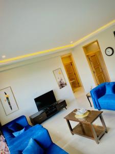 a living room with two blue chairs and a table at Snowra heights in Abbottabad