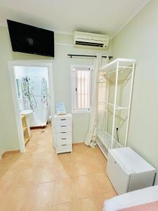 a room with a white dresser and a mirror at Hostal Cristina in Chipiona