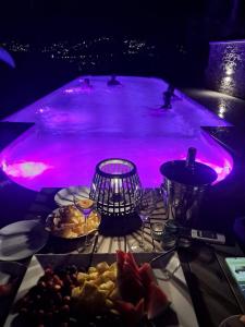 a table with food and a swimming pool with purple lights at Vista Resort OPENING 13-7-26 in Albisola Superiore