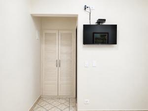 a room with a door with a tv on the wall at Hotel Pousada Garoupas in São Sebastião