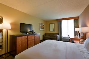 a hotel room with a bed and a flat screen tv at Wyndham Columbus in Worthington