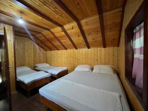 a room with two beds in a wooden cabin at Vikendica Jablaničko jezero in Jablanica +17 photos