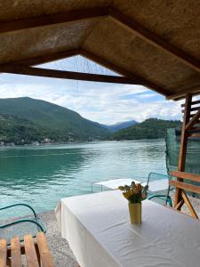 a table with a vase of flowers on top of a lake at Vikendica Jablaničko jezero in Jablanica