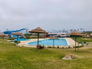 a swimming pool with umbrellas and a water park at Parque De Campismo Orbitur Sao Pedro De Moel in São Pedro de Moel