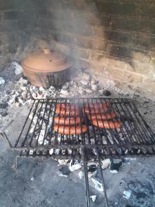 a grill with a bunch of hot dogs on it at Apartman Maga 2 in Gnjilišta +2 photos