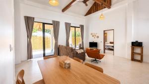 a living room with a wooden table and a couch at Maprao Tropical Home in Ko Phangan
