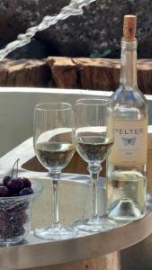 two glasses of white wine next to a bottle of wine at Healing Hands in Merom Golan
