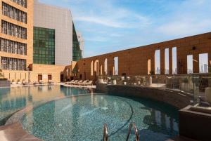 a large swimming pool in front of a building at Radisson Collection Residences, Riyadh in Riyadh