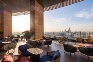 a restaurant with tables and chairs and a view of the city at Radisson Collection Residences, Riyadh in Riyadh
