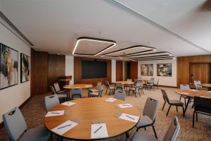 a conference room with tables and chairs and a screen at Radisson Collection Residences, Riyadh in Riyadh +134 photos