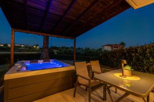 a hot tub in a deck with a table and chairs at Afitos Luxury Villas in Afitos