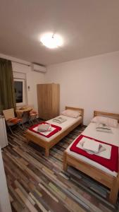 a room with two beds and a room with chairs at Apartments Vukelić in Starigrad