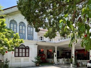 a large white building with blue shutters at Modern 12th Floor Condo Walk to Phuket Old Town with Pool & Gym in Phuket