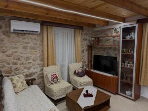 a living room with a couch and chairs and a tv at The Stone Loft in Arfará