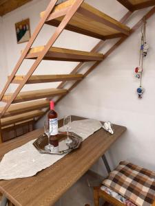 a wooden table with a bottle of wine and glasses at The Stone Loft in Arfará