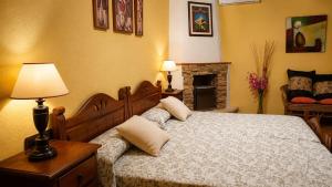 a bedroom with a bed with a lamp and a fireplace at Hostal Don Juan in Alarcón