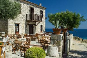 a restaurant with tables and chairs and the ocean at Afitos Luxury Villas in Afitos
