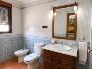 a bathroom with a toilet and a sink and a mirror at Hostal Don Juan in Alarcón