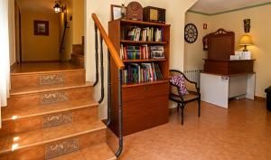 a room with a book shelf and stairs with a chair at Hostal Don Juan in Alarcón