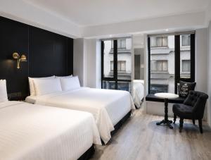 a hotel room with two beds and a chair at Hotel Relax III in Taipei