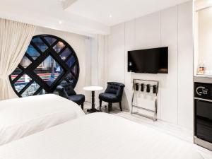 a hotel room with two beds and a flat screen tv at Hotel Relax III in Taipei