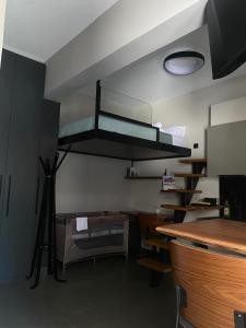 a room with a bunk bed and a desk at The swanky studio in Anatolí