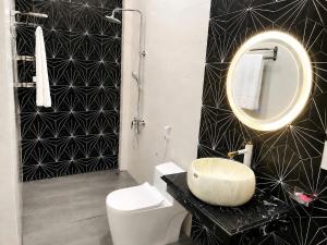 a black and white bathroom with a sink and a mirror at Homestay ĐAN MY 2 in Trung Nghĩa