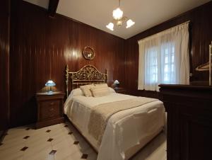 a bedroom with a bed with wooden walls and a window at Chalet cerca de la playa de Esmelle in Pedreira