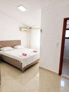 a bedroom with a bed with pink towels on it at Esko Rooms in Donji Štoj