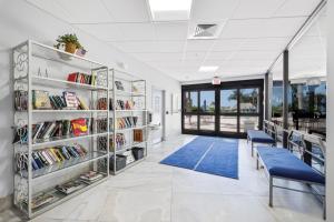 a library with shelves of books and a blue bench at Gorgeous beachfront condo with SW-facing balcony in Marco Island