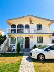 a white car parked in front of a house at Esko Rooms in Donji Štoj