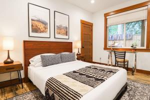 a bedroom with a bed and a desk and a window at Swiss Marmot in Glacier