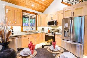 a kitchen with wooden cabinets and a stainless steel refrigerator at Swiss Marmot in Glacier