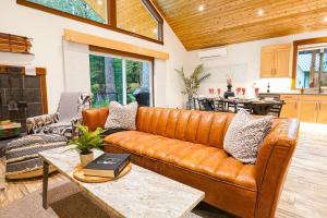 a living room with a leather couch and a table at Swiss Marmot in Glacier +36 photos