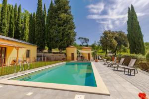 a swimming pool with chairs and a house at Casa Febea in Chiusi
