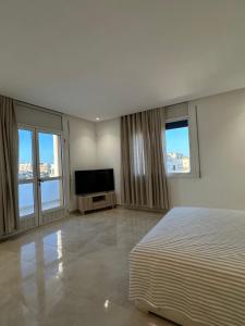 a bedroom with a bed and a flat screen tv at Dar Llama in Nador