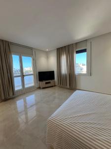 a bedroom with a bed and a flat screen tv at Dar Llama in Nador +6 photos
