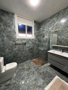 a bathroom with a shower and a toilet and a sink at Dar Llama in Nador