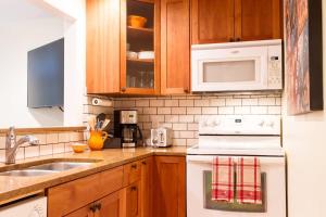 a kitchen with wooden cabinets and a white stove top oven at Rivers Edge at Snowater in Glacier