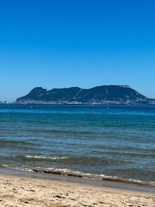 a view of the ocean with a mountain in the background at Centro Kennedy in Algeciras