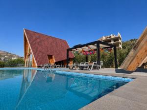 a swimming pool with a pavilion next to a house at M Place in Shārūn