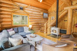 a living room with a couch and a fireplace in a log cabin at Stargazer Chalet in Glacier