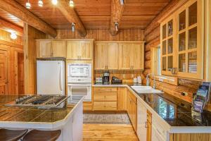 a kitchen with wooden cabinets and a white refrigerator at Stargazer Chalet in Glacier