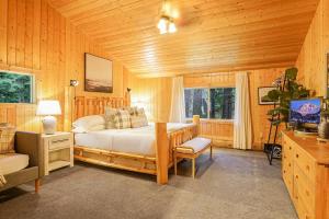 a bedroom with a bed and a television in it at Stargazer Chalet in Glacier