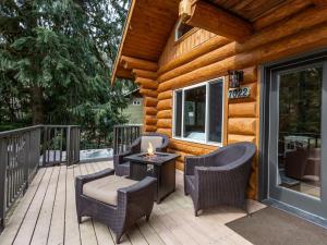 a porch with wicker chairs and a table with a candle at Stargazer Chalet in Glacier +41 photos