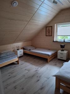 a room with two beds and a window in a attic at Domek Viking z prywatnym ogrzewanym basenem sauną oraz balią z jacuzzi in Gródek Nad Dunajcem +93 photos